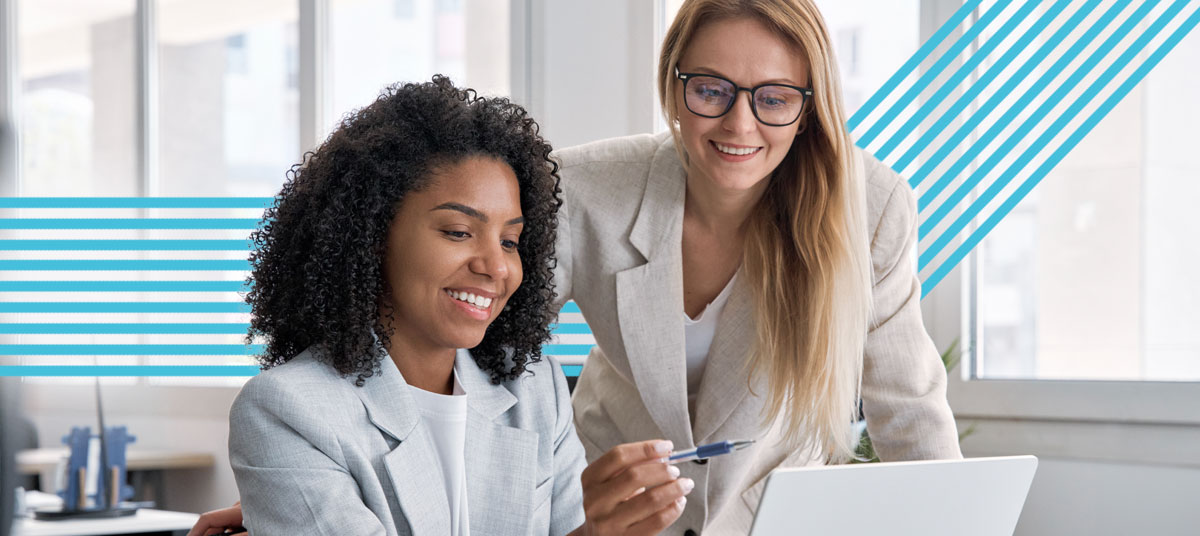 Two professional women reviewing data on a laptop