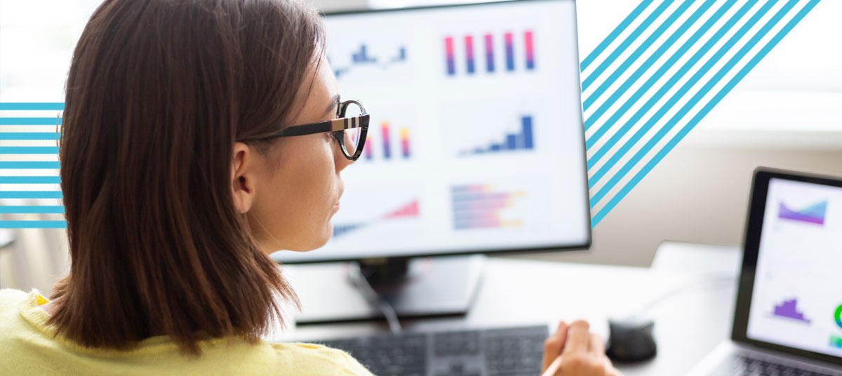 Marketing procurement manager overlooks data on computer screens